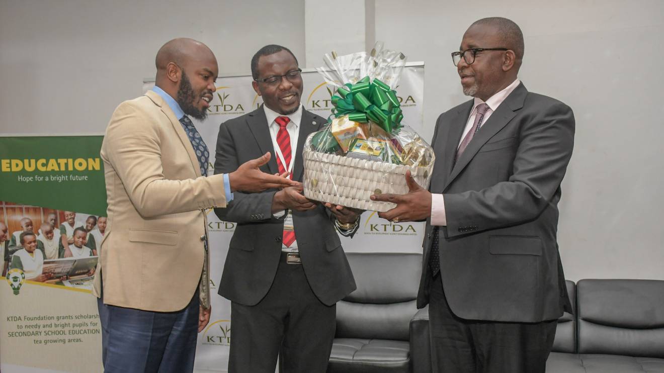 (Right to left): Mithika Linturi, receives a token of appreciation from the KTDA Holdings Chairman, Enos Njeru (centre and GG Kagombe (left) who is also a director at Theta Tea Factory. PHOTO/COURTESY